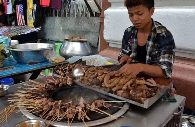 Enjoying Burmese pork offal skewers in Myanmar